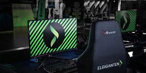 Skärm och gamingstol med Elgiganten-logga