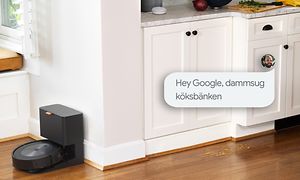 iRobot som dammsuger golvet i ett vitt kök med en pratbubbla med text på svenska.