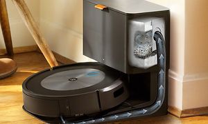 iRobot som står ansluten till en avfallsbehållare och pilar som pekar vart smutsen tar vägen.