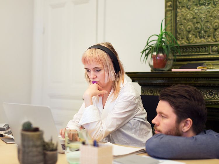 Kvinna och man tittar på en bärbar dator på skrivbord