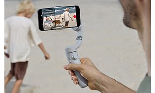 Man som filmar ett barn med DJI OM 5