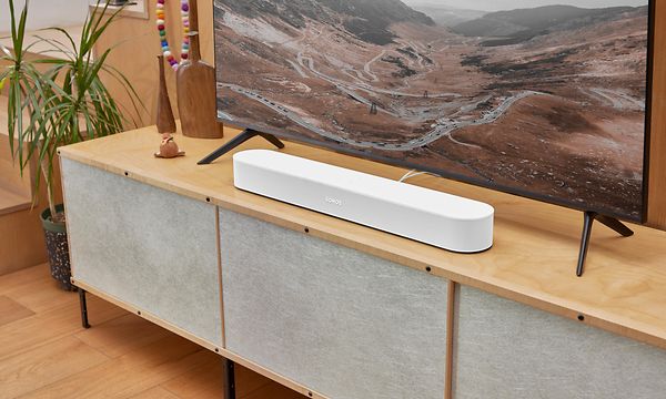 TV på tv-bänk med en vit sonos beam 2 under. 