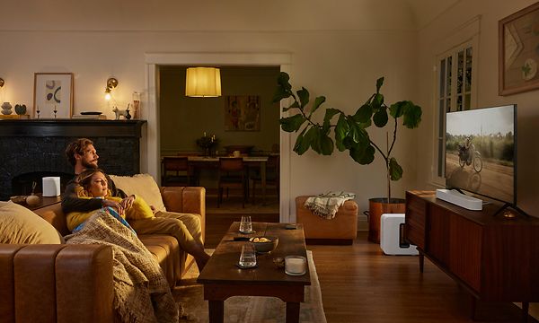 Ett par myser i soffan i vardagsrum och ser på TV med sonos beam 2. 