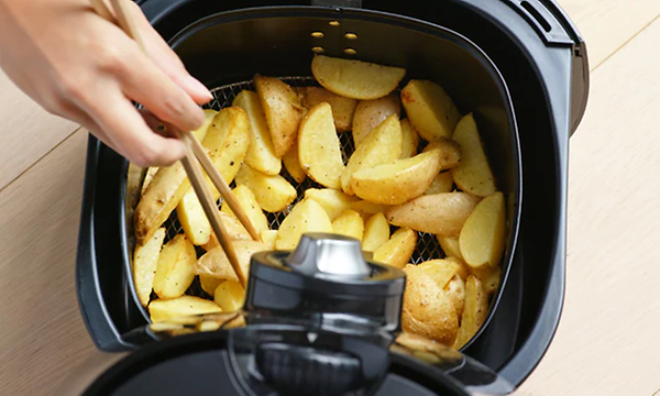 Potatisklyftor i en airfryer, bild ovanifrån. 