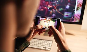 Person som spelar Hearthstone på en mobiltelefon