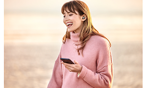Kvinna pratar i telefon med Jabra Elite 7 i öronen