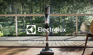 Skärmdump från video om Electrolux med bild på en skaftdammsugare med balkong som har utsikt över trädgård bakom.