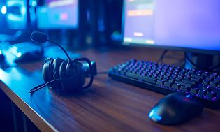 Gaming headset, tangentbord och mus på ett skrivbord