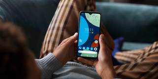 Fairphone 4 i handen på en liggande person