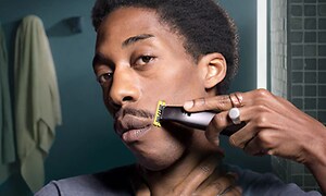 Man som trimmar sin mustasch med en Philips OneBlade Pro