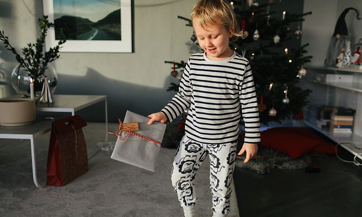Ett glatt barn håller i en julklapp