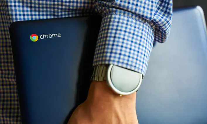 man med rutig skjorta håller en Chromebook