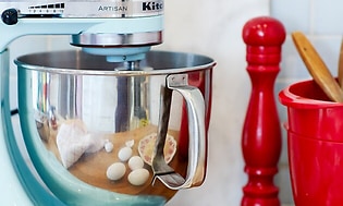 KitchenAid-maskin bredvid äggskal och röd köksutrustning
