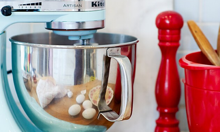 KitchenAid-maskin bredvid äggskal och röd köksutrustning