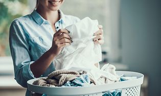 Woman folding laundry from a laundry basket