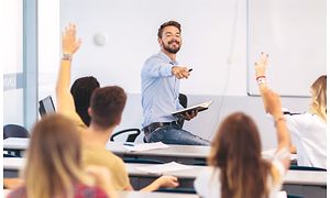 Airthings Wave Plus on a classroom wall behind teacher and students