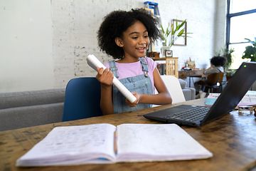 Ung flicka som gör sitt skolarbete med en bärbar dator
