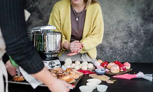 En kvinna som gör runda bullar och en Ankarsrums köksmaskin