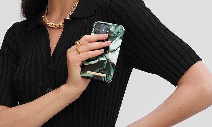 IDEAL OF SWEDEN phone cover on smartphone held by a woman posing