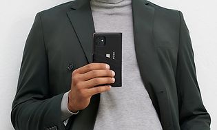 IDEAL OF SWEDEN phone cover with wallet on smartphone held by a man posing
