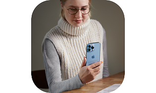 Young woman holding an iPhone 13 in her hand