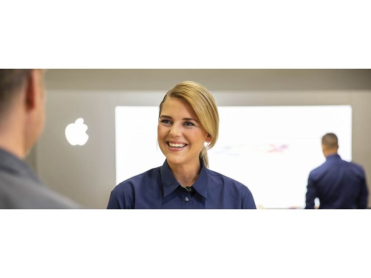 Apple - B2B - Female Elkjøp salesperson and a customer in a store with Apple logo