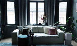 En grå Pure A9 står bredvid en vit soffa i ett mörkt vardagsrum