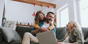 Familj använder dator medan de har kul