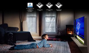LG OLED TV i ett mysigt vardagsrum med ett barn som ligger på golvet framför den