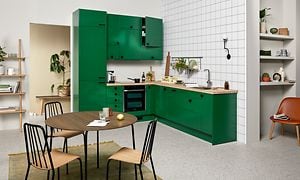 Grönt EPOQ Trend-kök i öppen kökslösning med integrerad ugn och träbänkskiva samt matbord
