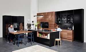 Svart EPOQ Edge kök med öppen planlösning, köksö och köksbord i mitten i brunt och svart. 