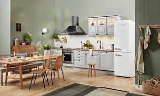 Ljusgrått kök från EPOQ med gröna väggar, köksbord i trä och vita vitvaror från smeg.