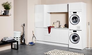Vit tvättstuga från EPOQ Integra med rosa väggar och tvättmaskin samt torktumlare.