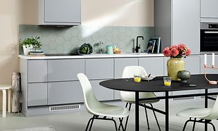 Ljusgrått kök från EPOQ Integra med svart köksbord och vita stolar.
