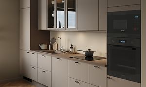 Sandfärgat EPOQ Trend kök med integrerad ugn och brun bänkskiva med induktionshäll och diskho med silverfärgad kran. Glasskåp