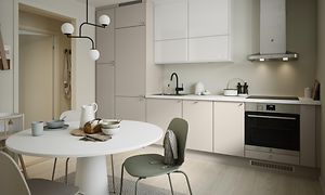 EPOQ Trend kök i vit och ljusbeige färg med öppen planlösning, vitt köksbord, och integrerad ugn med vit köksfläkt.