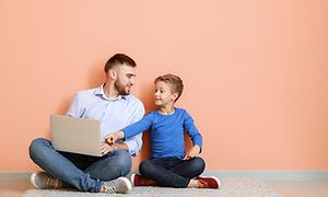 En man och en pojke med en bärbar dator