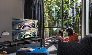 Två personer som spelar videospel i vardagsrum
