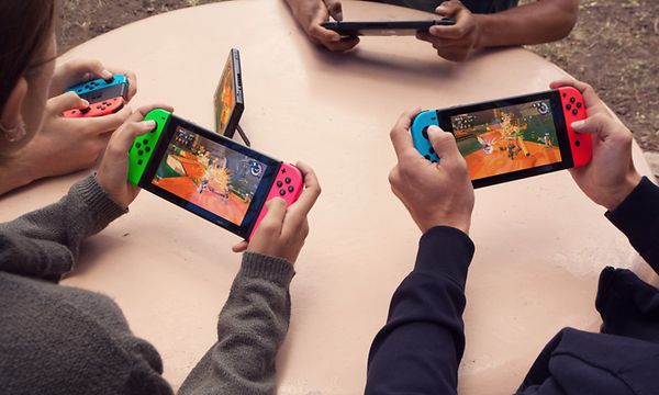 Barn som sitter runt bord och spelar på varsin Switch-konsol