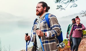 Fitbit Charge 5 - Glada personer som går på en stig med sina Fitbits på armen
