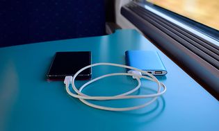 Powerbank som laddar en telefon på ett tåg