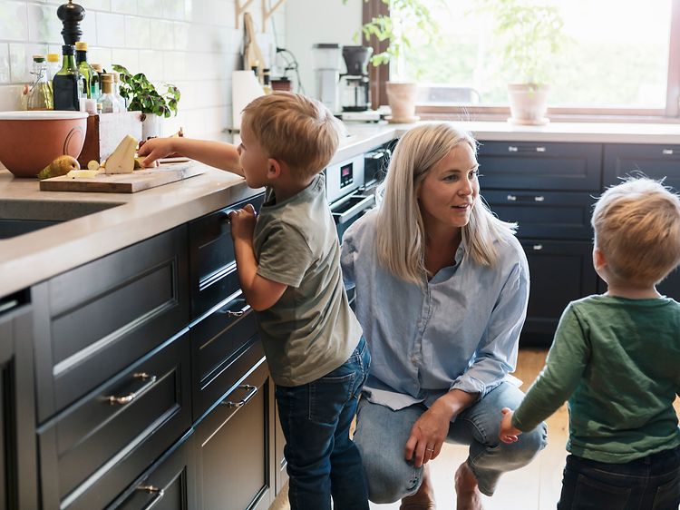 Kvinna med två barn i ett kök