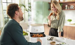 Philips Airfryer och en man och en kvinna vid ett bord