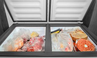 Frysbox med öppen dörr och fryst mat som syns