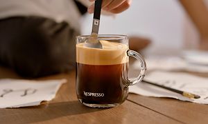 Hand som rör om kaffet med en sked