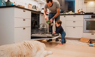 MDA-Dishwashers-Man och liten pojke lägger in disk i en stor diskmaskin