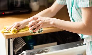 MDA-Dishwashers-Kvinna rengör köksbänk med inbyggd diskmaskin under