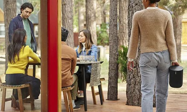 Kvinna bär Sonos Move utanför ett café