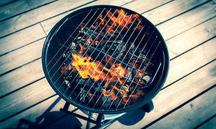 En brinnande kolgrill på en veranda.