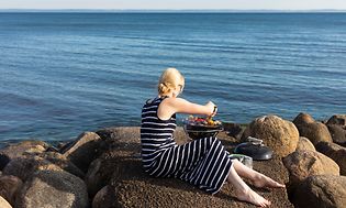 Kvinna som grillar vid vattnet